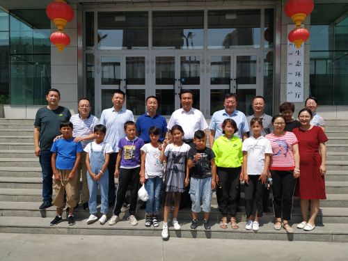 生态环境厅厅长乌拉孜别克?热苏力汗与阿克苏地区乌什县阿克托海乡生态环境厅“访惠聚”驻村工作队所在村参加夏令营的小朋友们在厅机关楼前留影